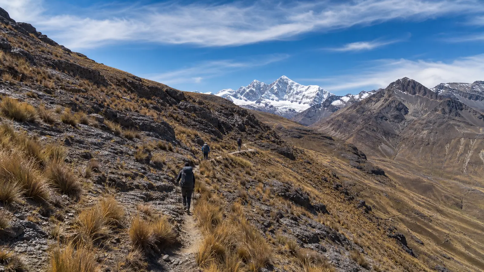 Guided hikers following a high Andean trail toward the first major pass of the Huayhuash circuit
