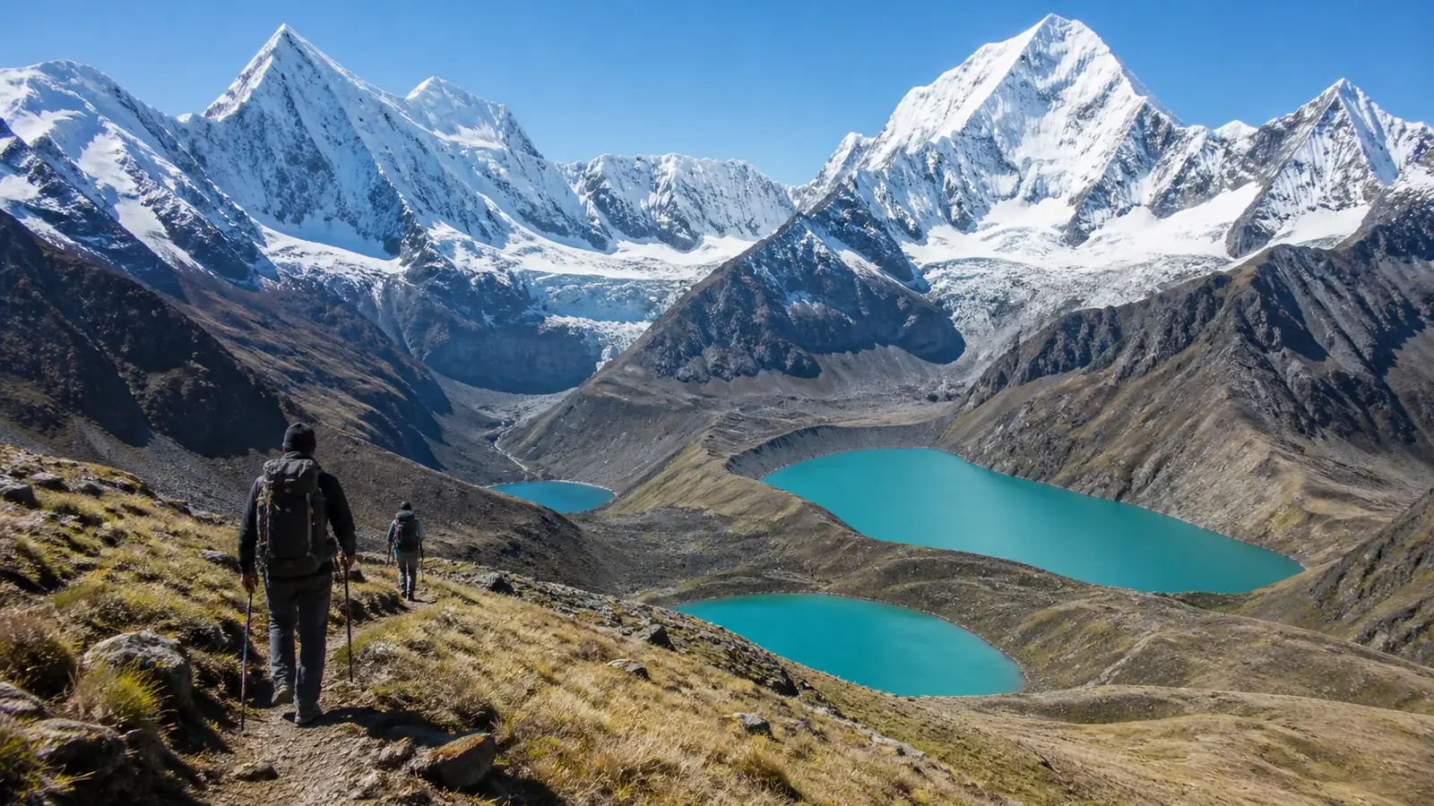 Hikers following the high trail above three turquoise glacial lakes on a scenic Huayhuash stage
