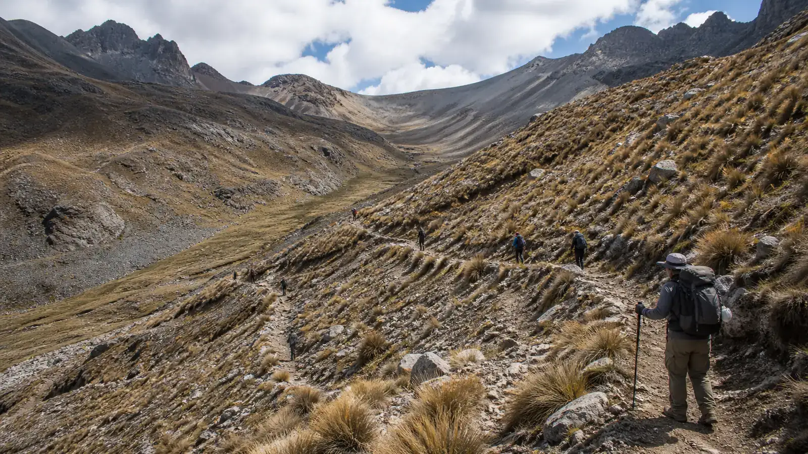 Trekkers following a steady pace on a long switchback ascent toward a high pass in the Cordillera Huayhuash